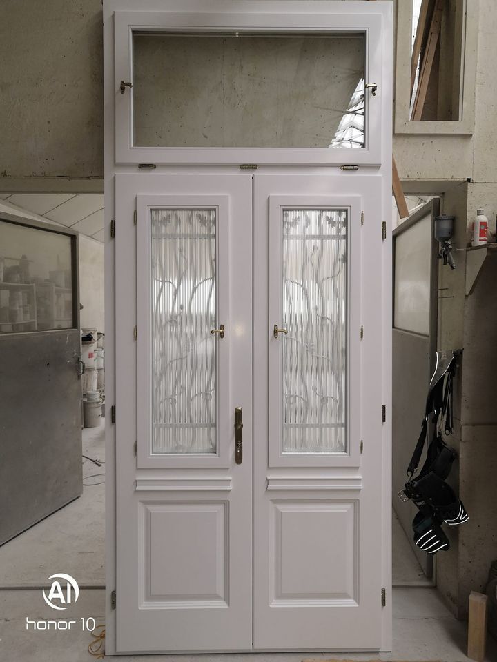 Társasház bejárati ajtó kovácsoltvas díszítéssel és üvegbetéttel